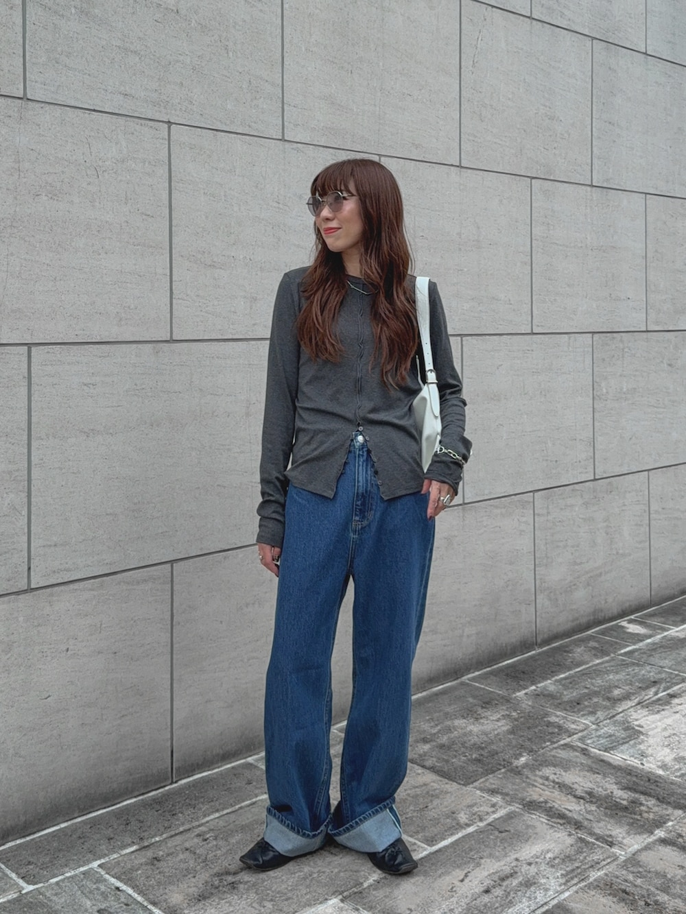 グレー系のTシャツ/カットソー、ブルー系のデニムパンツ、ホワイト系のバッグを着用したレディースの秋コーディネートの2枚目の写真