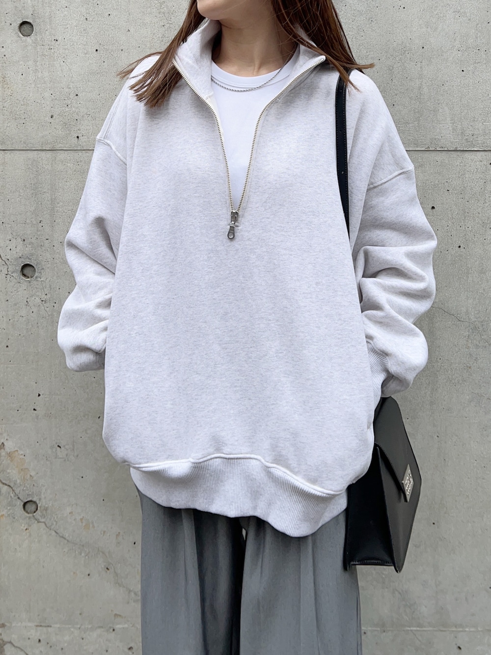 グレー系のスウェット、グレー系のスラックス、ブラック系のモカシン/デッキシューズを着用したレディースの冬コーディネートの4枚目の写真