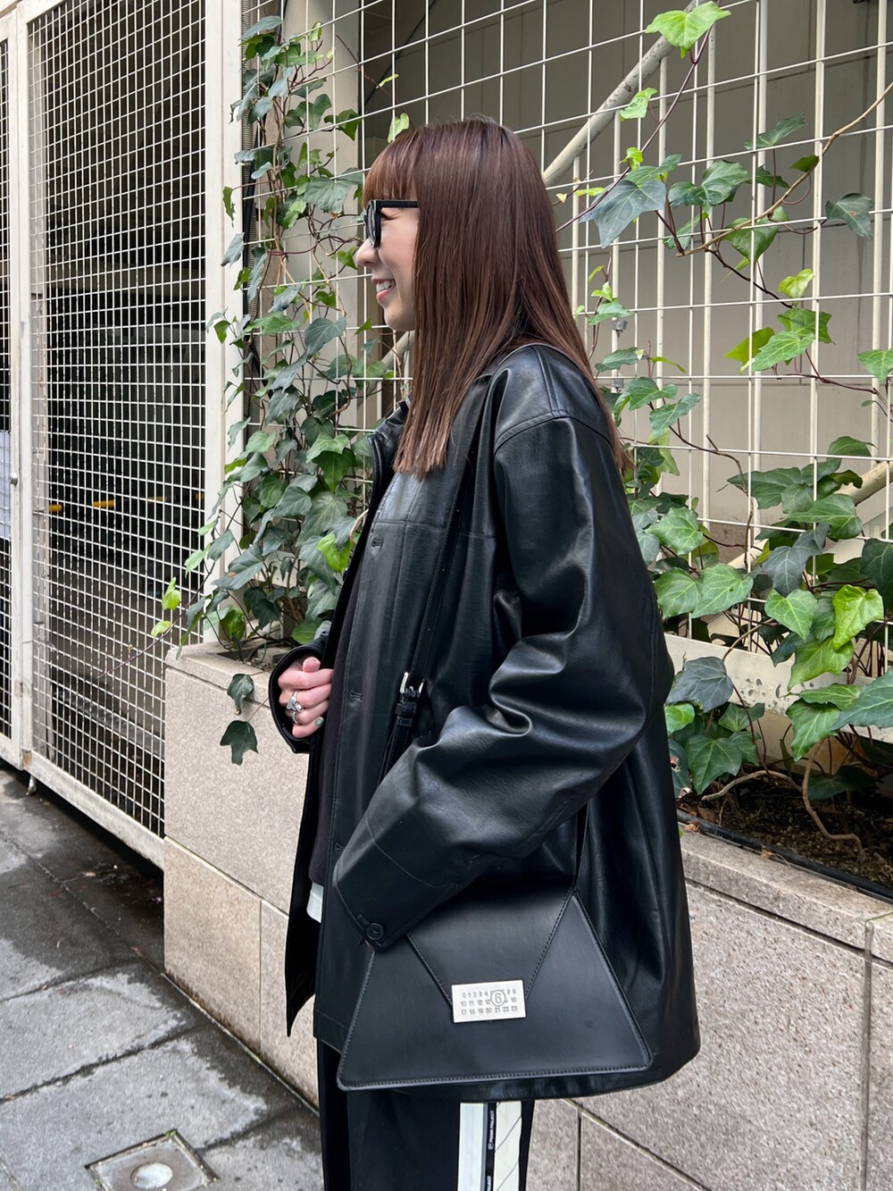 ブラック系のその他アウター、ブラック系のニット/セーター、ホワイト系のTシャツ/カットソーを着用したレディースの冬コーディネートの4枚目の写真