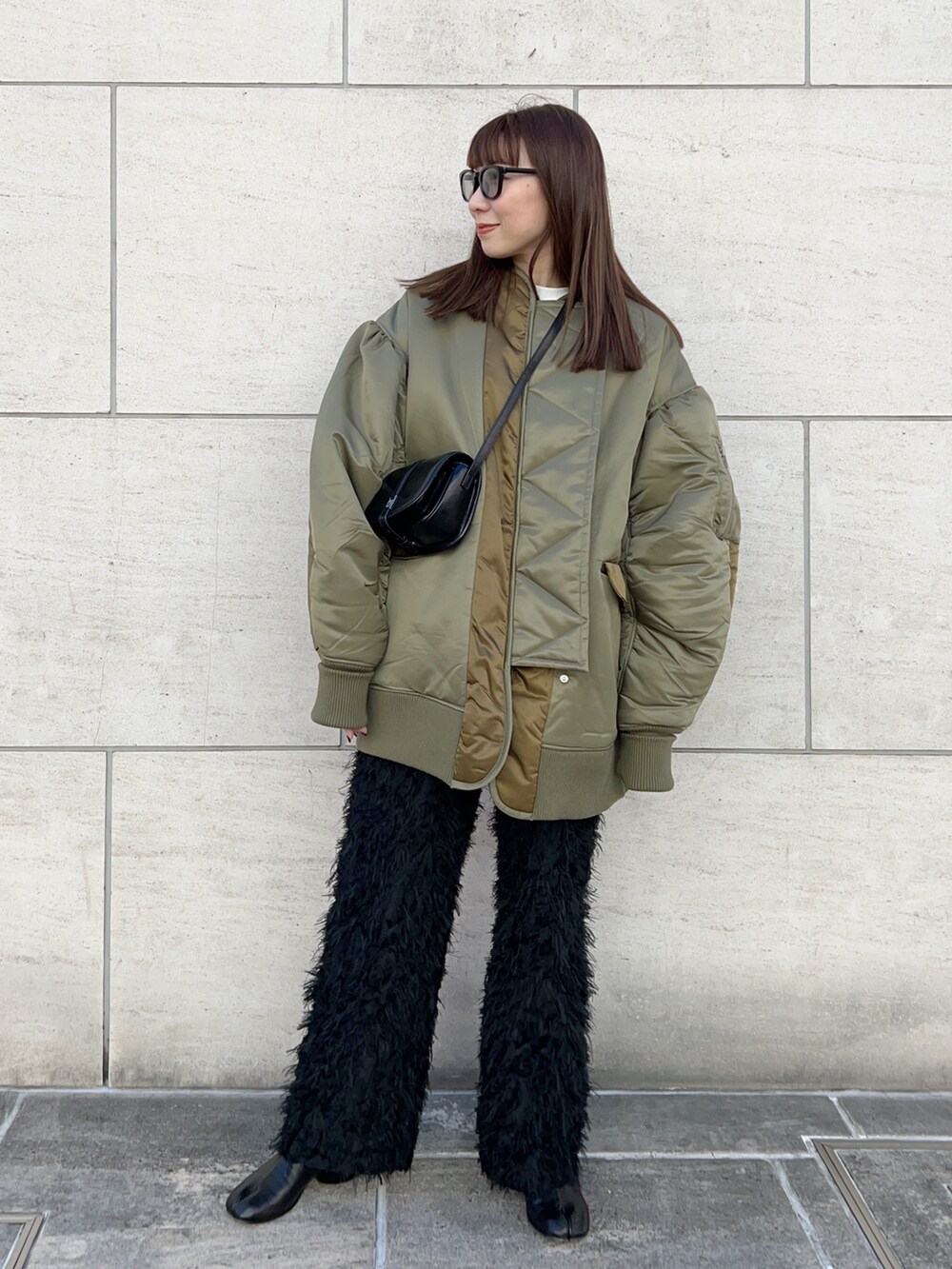 グリーン系のブルゾン、ブラック系のショルダーバッグ、ブラック系のその他パンツを着用したレディースの冬コーディネートの2枚目の写真