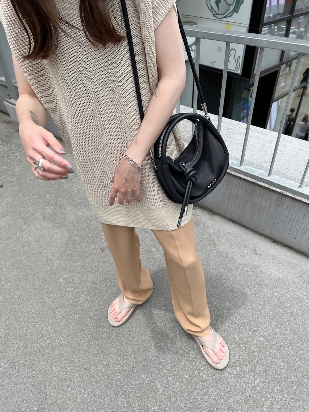 ベージュ系のトップス、ベージュ系のスラックス、ベージュ系のサンダルを着用したレディースの夏コーディネートの4枚目の写真