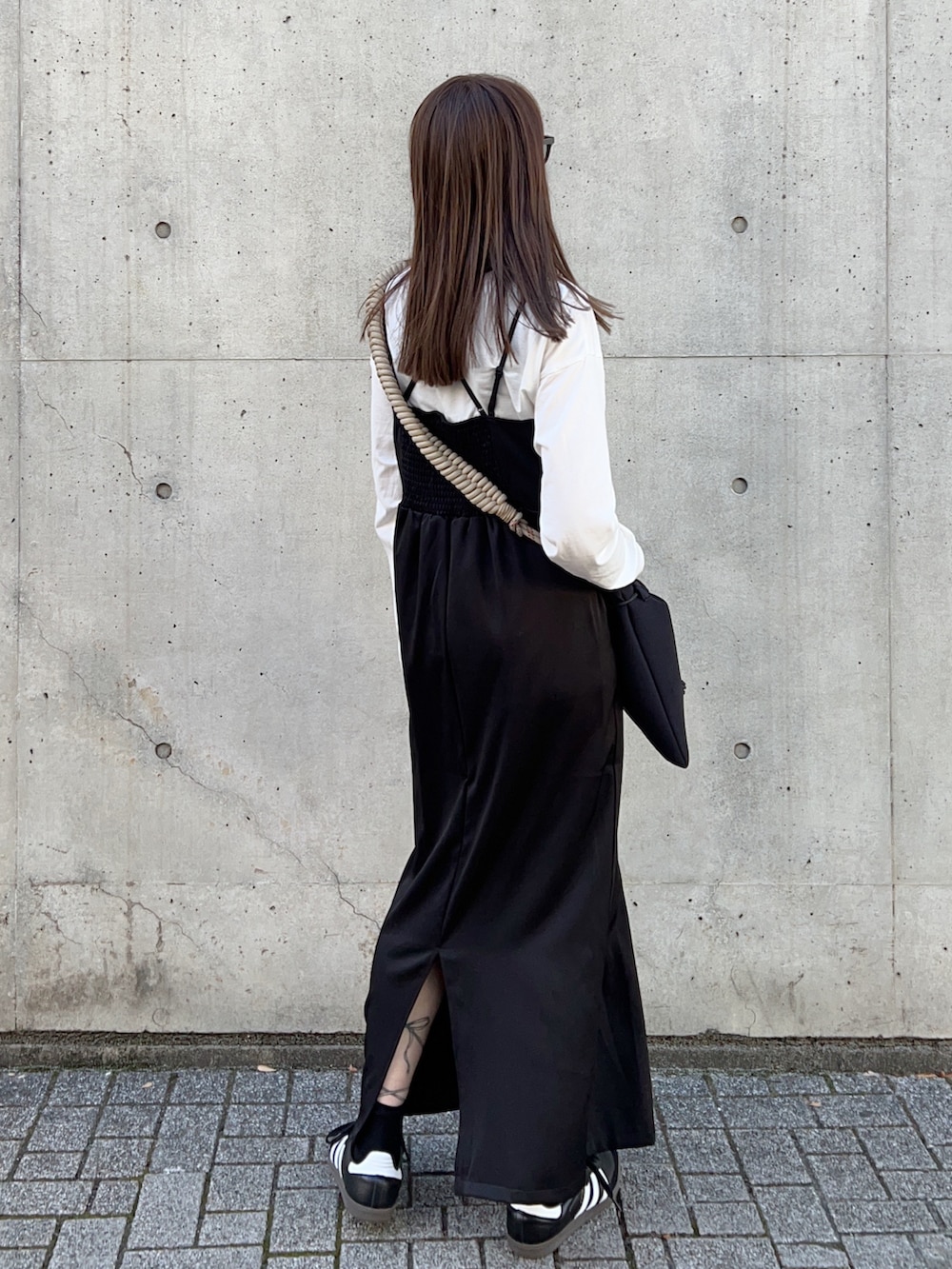 グリーン系のブルゾン、ベージュ系のショルダーバッグ、ブラック系のワンピースを着用したレディースの冬コーディネートの5枚目の写真