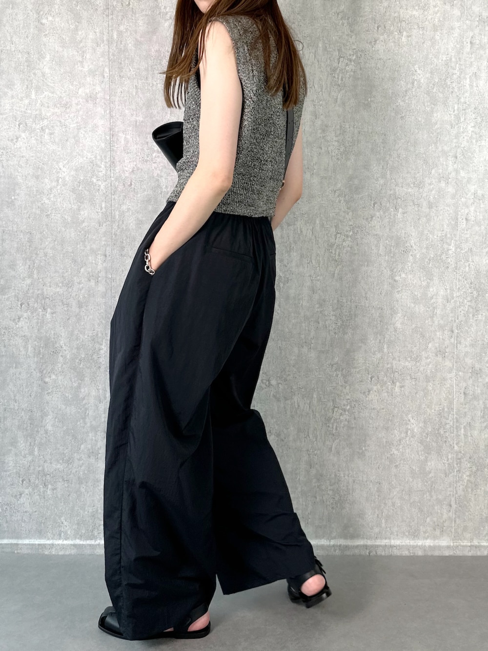 ブラック系のその他パンツ、ブラック系のベスト、ブラック系のショルダーバッグを着用したレディースの夏コーディネートの4枚目の写真