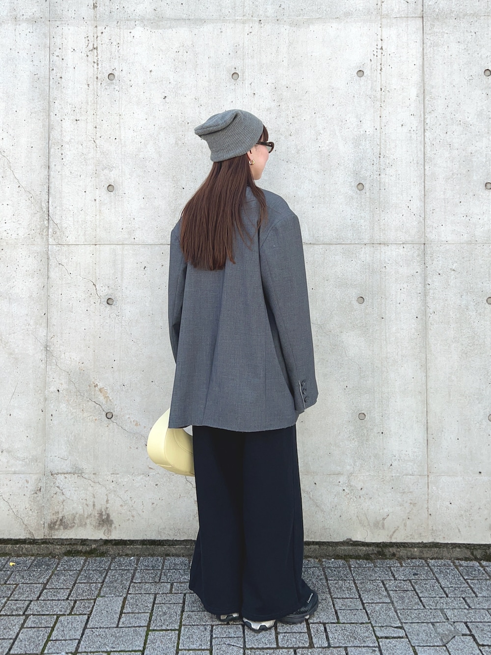 グレー系のテーラードジャケット、ホワイト系のTシャツ/カットソー、イエロー系のハンドバッグを着用したレディースの春コーディネートの4枚目の写真