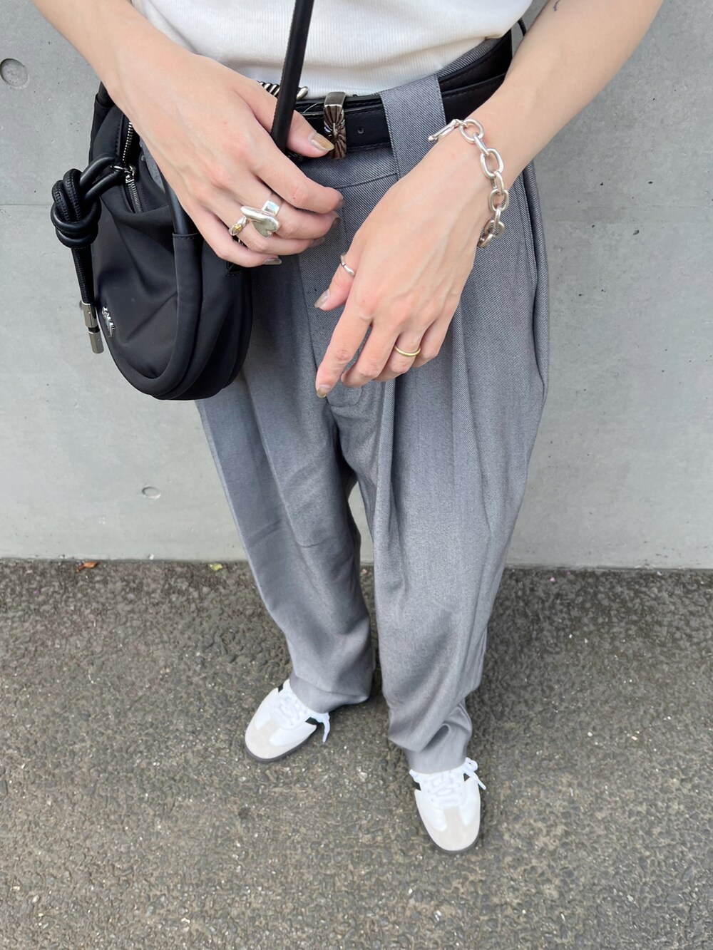 ホワイト系のタンクトップ、グレー系のスラックス、ホワイト系のスニーカーを着用したレディースの夏コーディネートの3枚目の写真