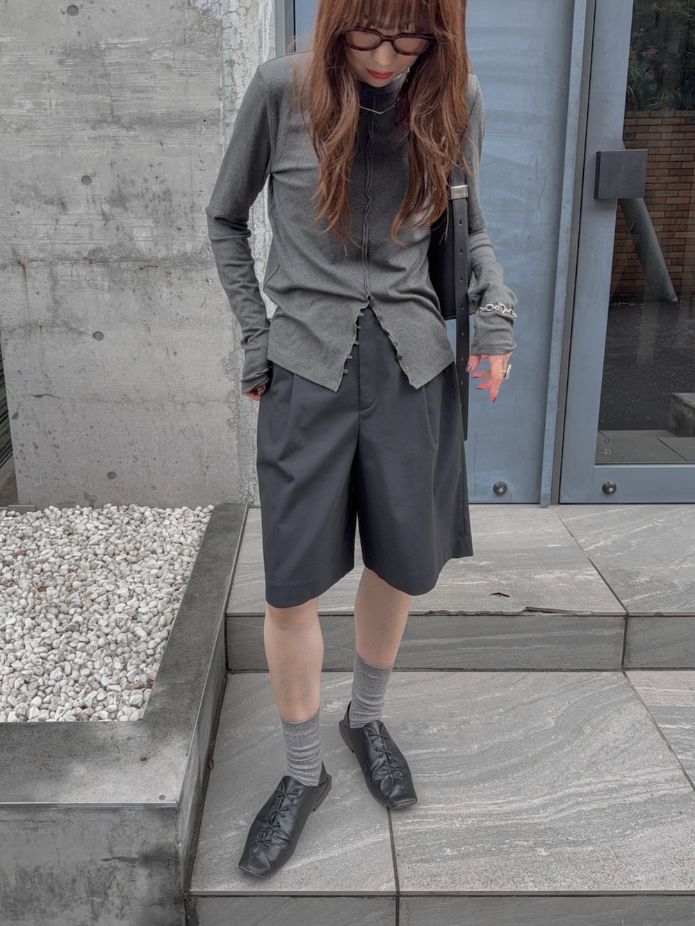 ブラック系のその他パンツ、グレー系のTシャツ/カットソー、ブラック系のバッグを着用したレディースの秋コーディネートの3枚目の写真