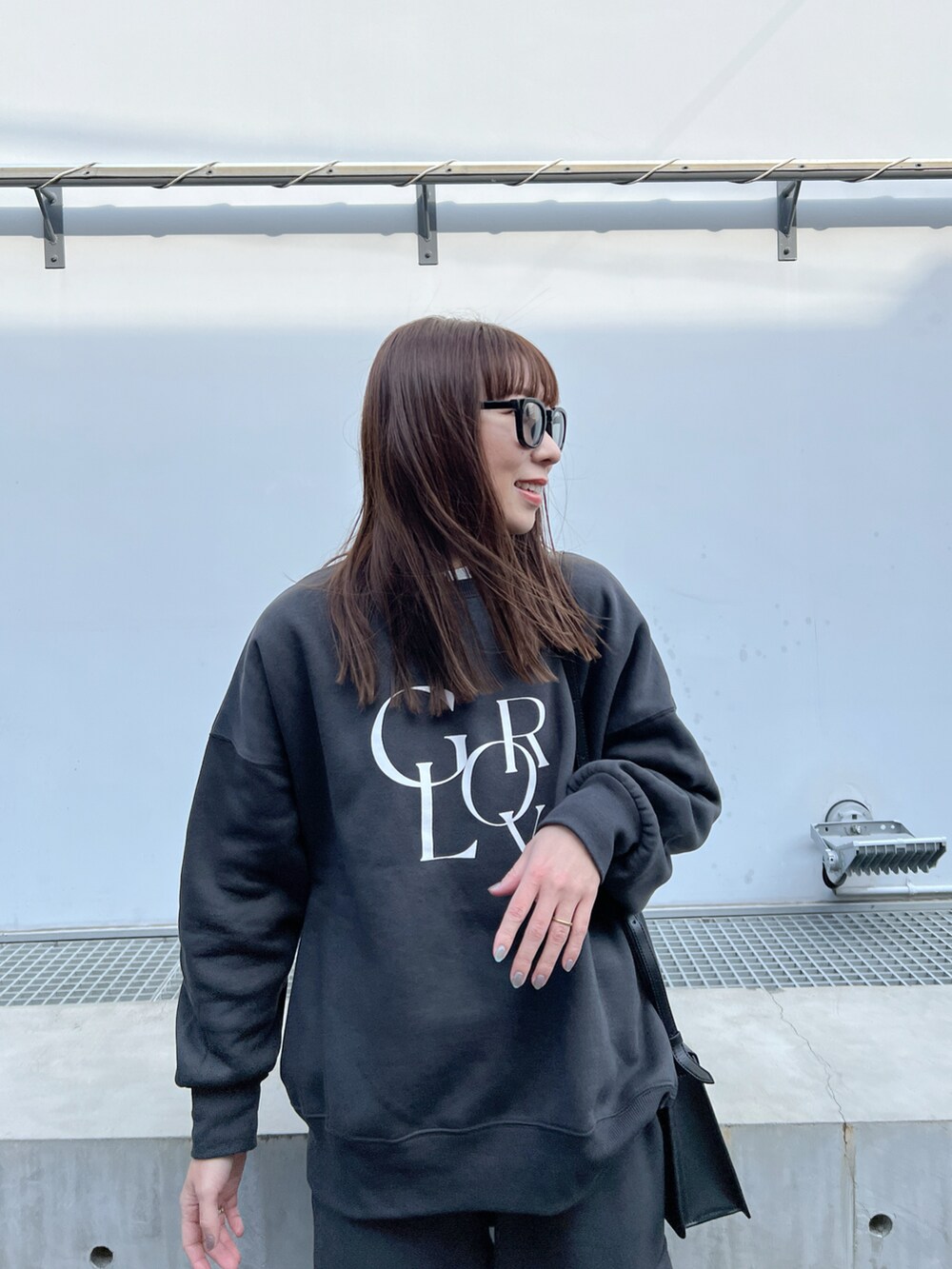 ブラック系のショルダーバッグ、グレー系のスウェット、グレー系のカーゴパンツを着用したレディースの冬コーディネートの4枚目の写真