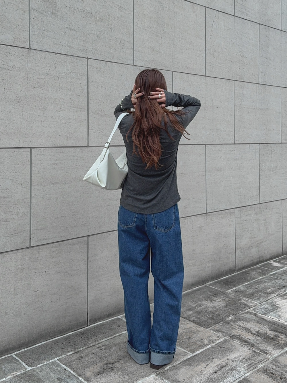 グレー系のTシャツ/カットソー、ブルー系のデニムパンツ、ホワイト系のバッグを着用したレディースの秋コーディネートの3枚目の写真