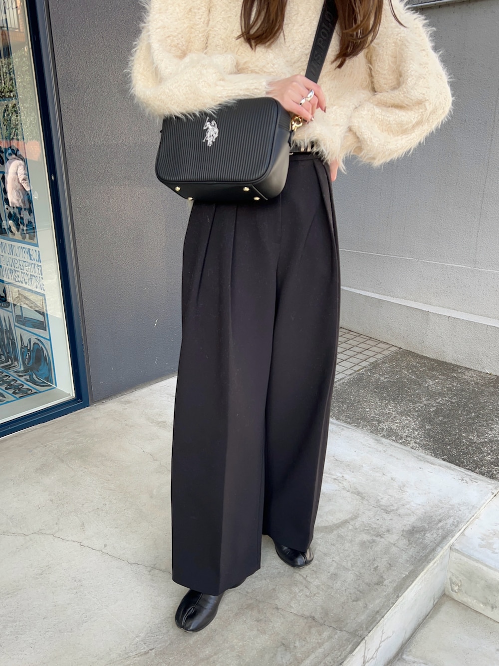 ホワイト系のニット/セーター、ブラック系のその他パンツ、ブラック系のショルダーバッグを着用したレディースの冬コーディネートの2枚目の写真