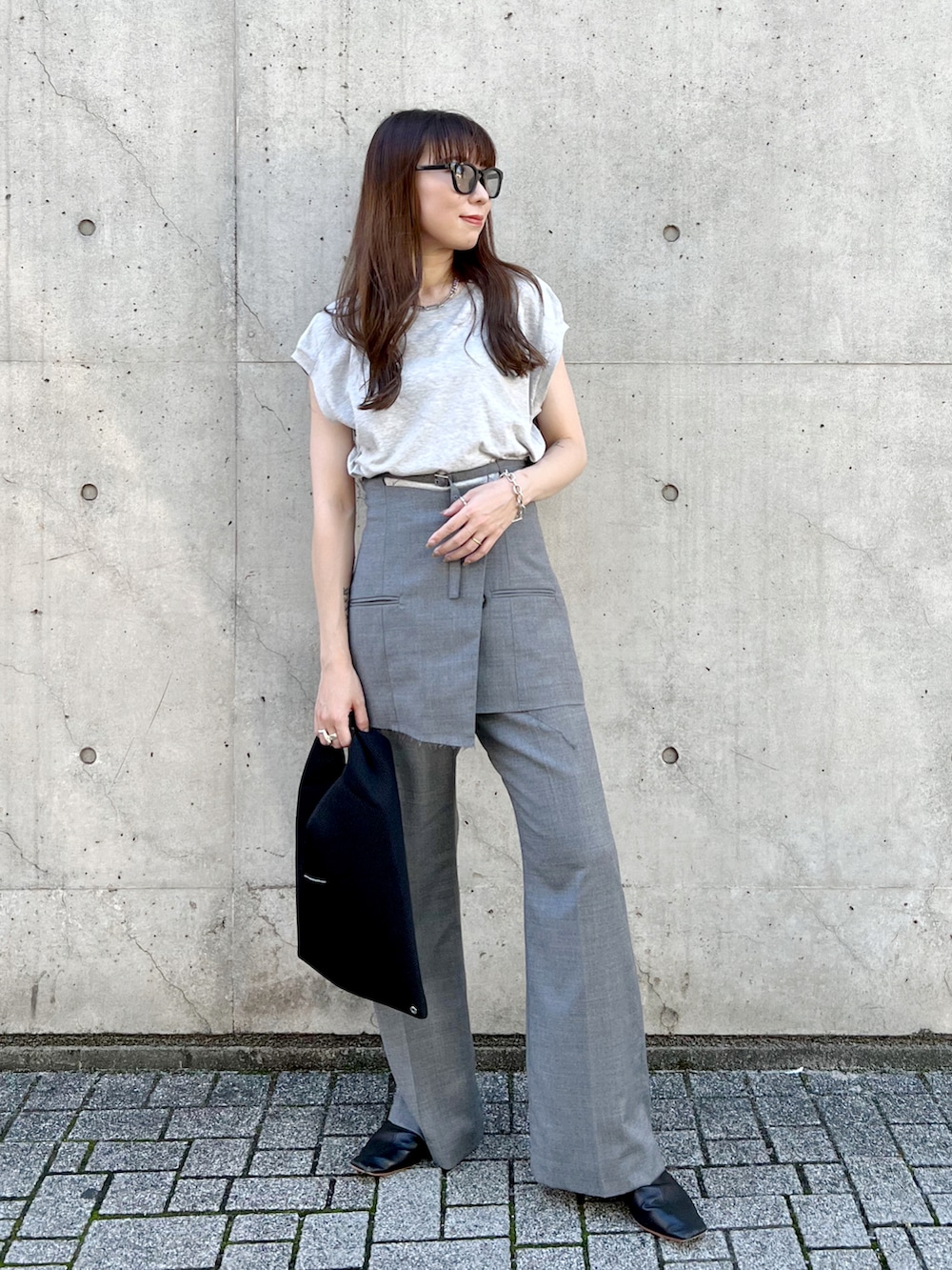 グレー系のTシャツ/カットソー、グレー系のスラックス、ブラック系のトートバッグを着用したレディースの秋コーディネートの2枚目の写真