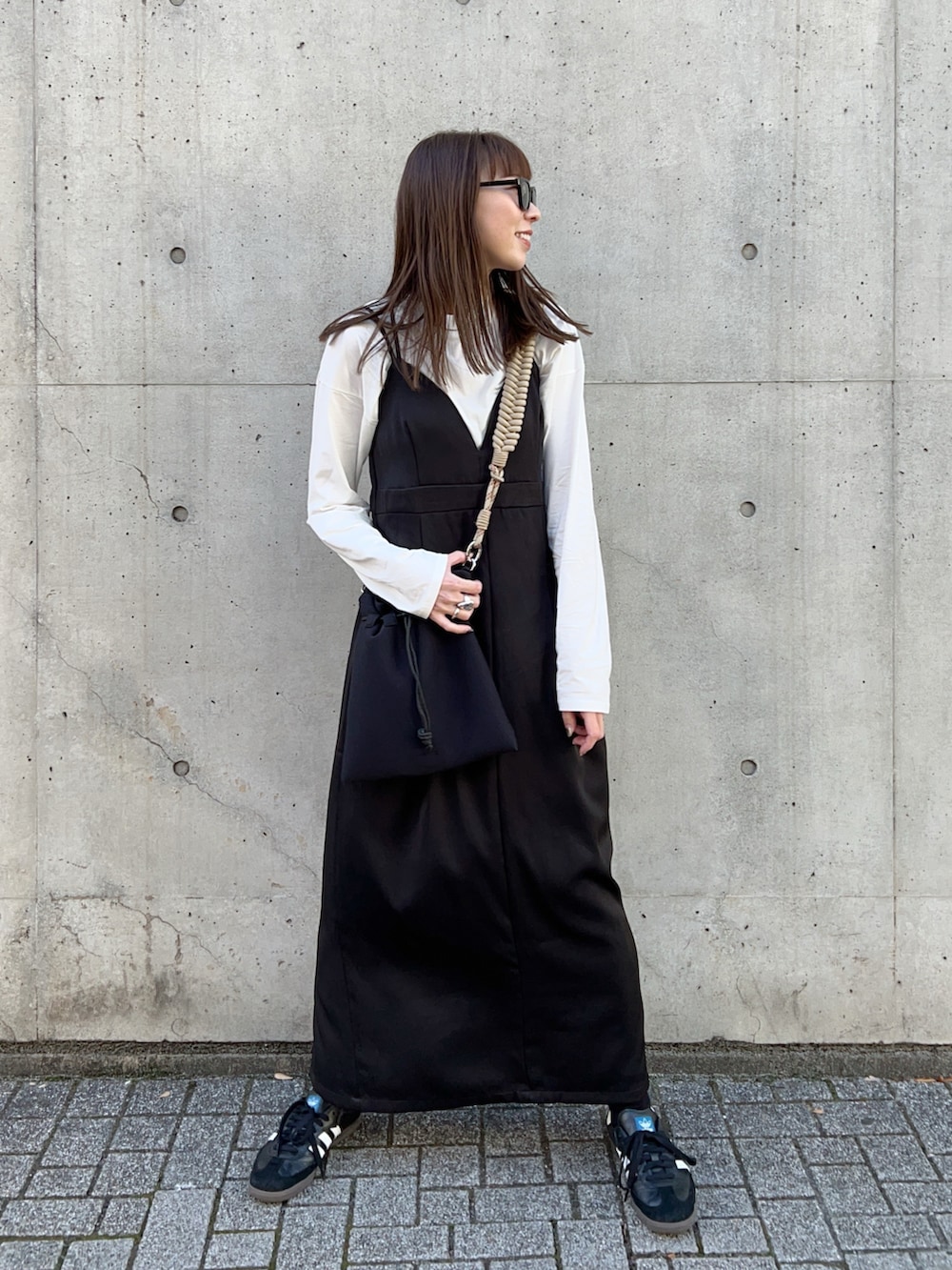 グリーン系のブルゾン、ベージュ系のショルダーバッグ、ブラック系のワンピースを着用したレディースの冬コーディネートの4枚目の写真