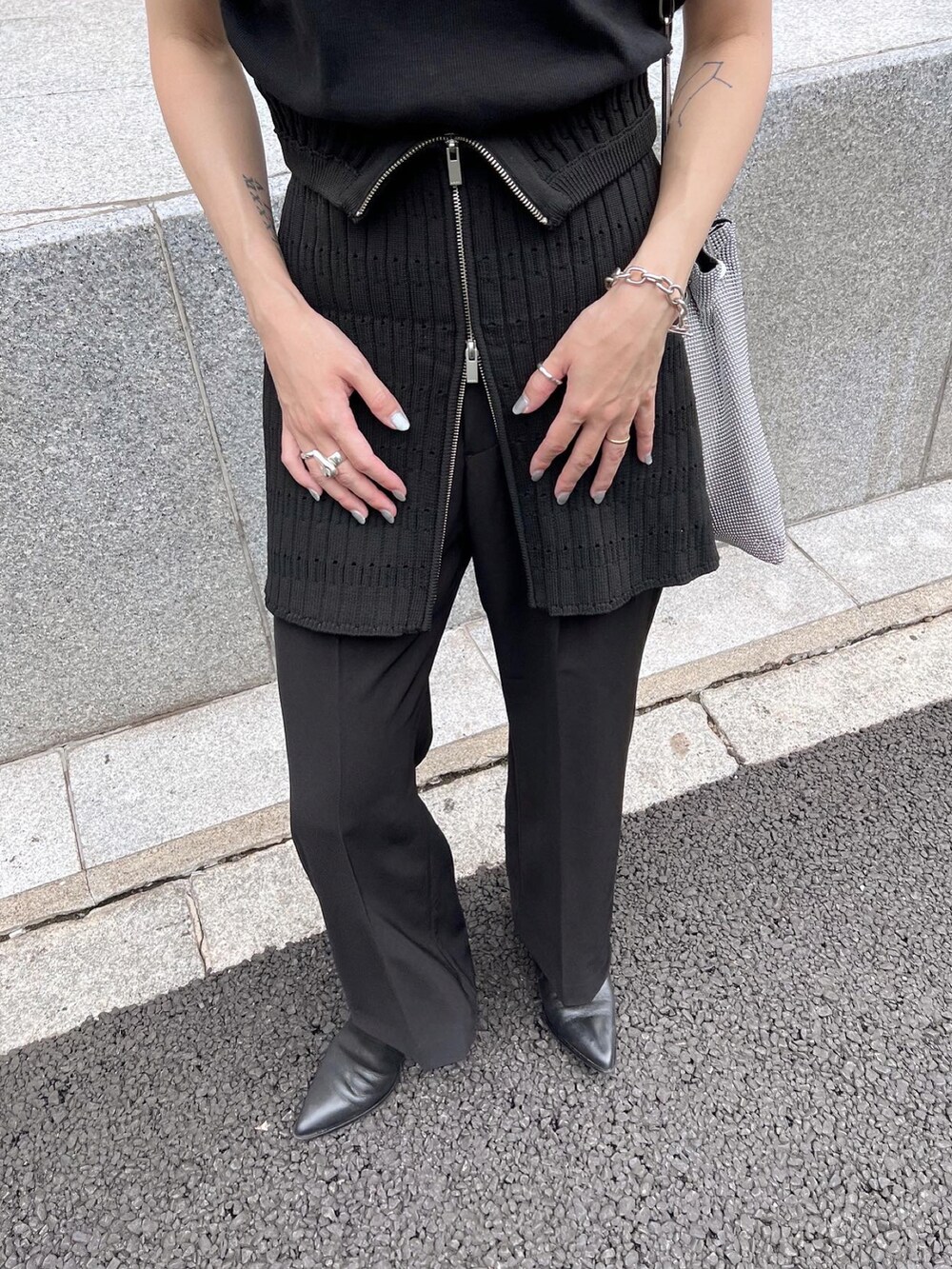 ブラック系のTシャツ/カットソー、ブラック系のスラックス、ブラック系のブーツを着用したレディースの秋コーディネートの4枚目の写真