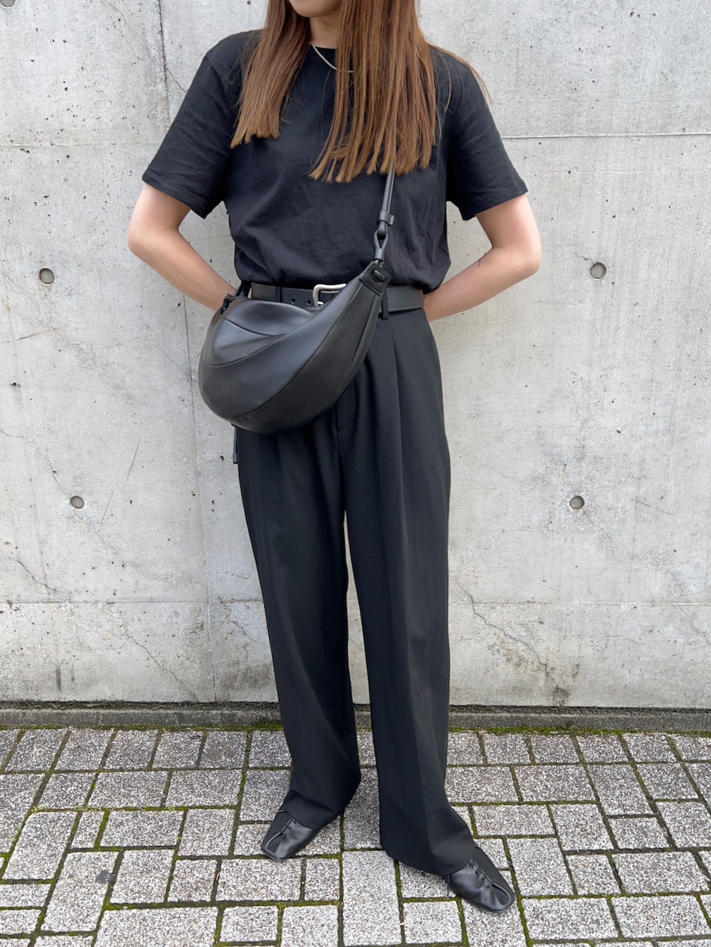 ブラック系のTシャツ/カットソー、ブラック系のスリッポン、ブラック系のパンツを着用したレディースの春コーディネートの4枚目の写真