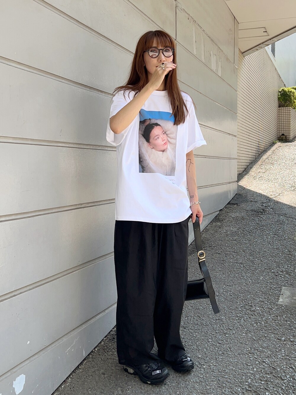 ホワイト系のTシャツ/カットソー、ブラック系のパンツ、ブラック系のショルダーバッグを着用したレディースの夏コーディネートの2枚目の写真