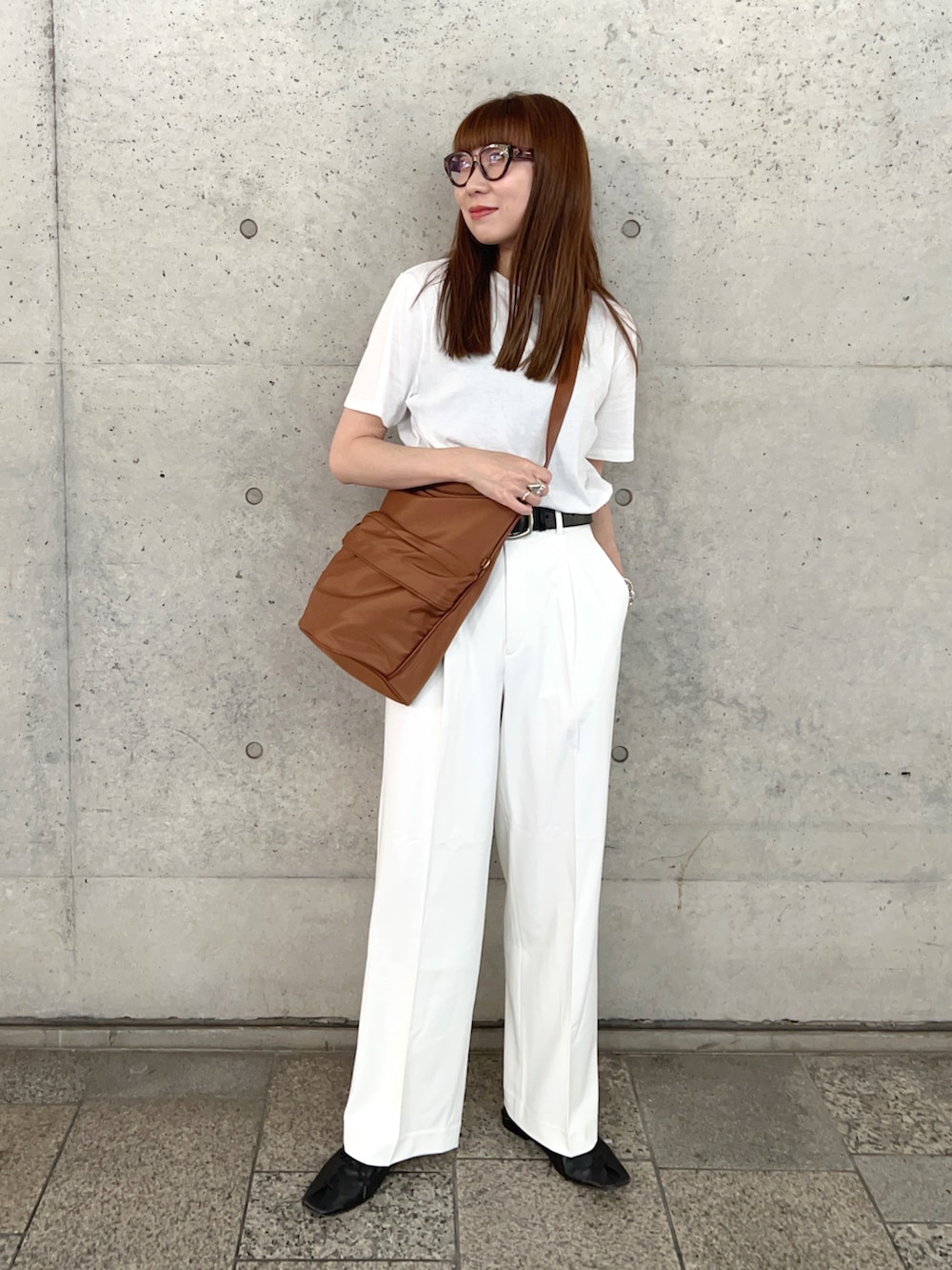 ホワイト系のTシャツ/カットソー、ブラック系のスリッポン、ホワイト系のパンツを着用したレディースの春コーディネートの2枚目の写真