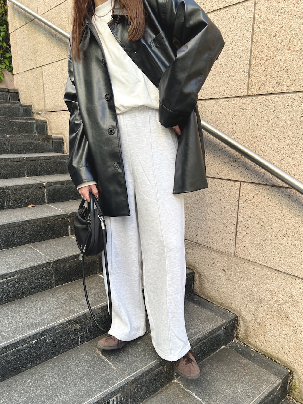 ブラック系のその他アウター、ベージュ系のスウェットパンツ、ホワイト系のTシャツ/カットソーを着用したレディースの秋コーディネートの5枚目の写真