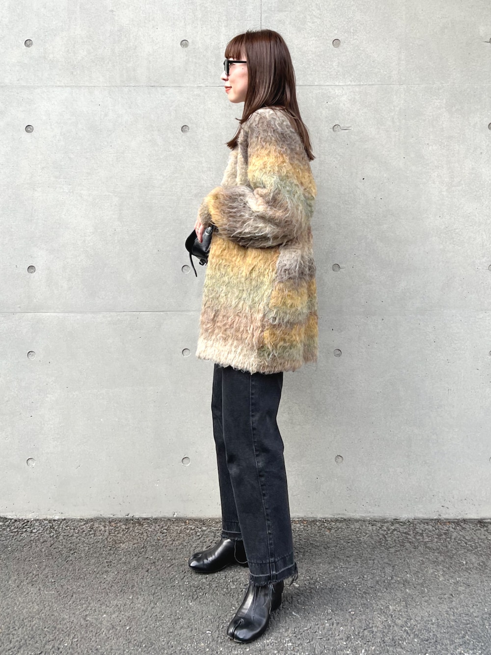 ベージュ系のカーディガン/ボレロ、ホワイト系のTシャツ/カットソー、ブラック系のショルダーバッグを着用したレディースの秋コーディネートの3枚目の写真