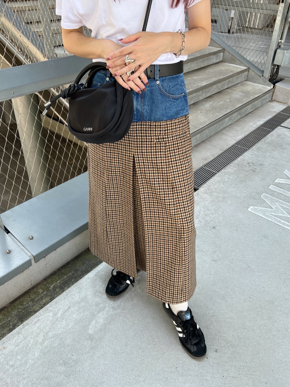 ベージュ系のスカート、ブラック系のスニーカー、ブラック系のショルダーバッグを着用したレディースの秋コーディネートの4枚目の写真