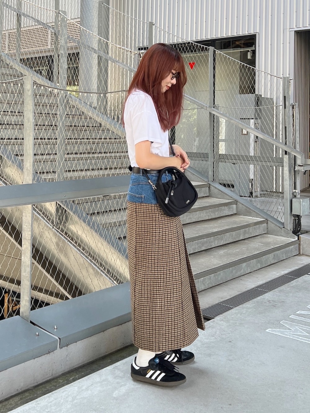 ベージュ系のスカート、ブラック系のスニーカー、ブラック系のショルダーバッグを着用したレディースの秋コーディネートの2枚目の写真