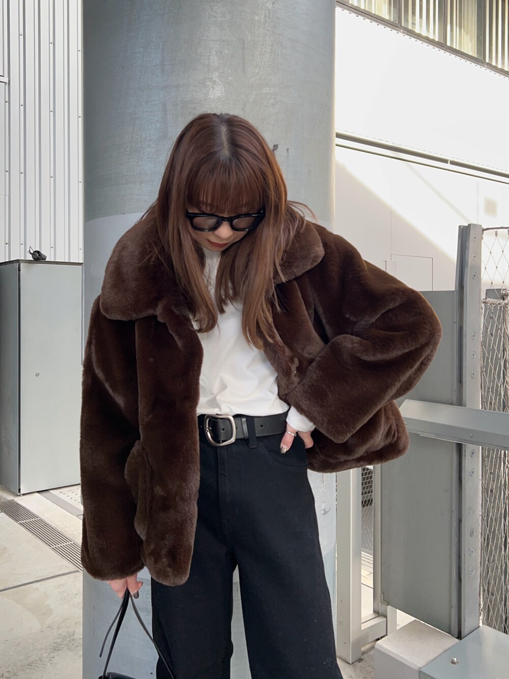 ブラウン系のブルゾン、ホワイト系のTシャツ/カットソー、ブラック系のショルダーバッグを着用したレディースの冬コーディネートの2枚目の写真