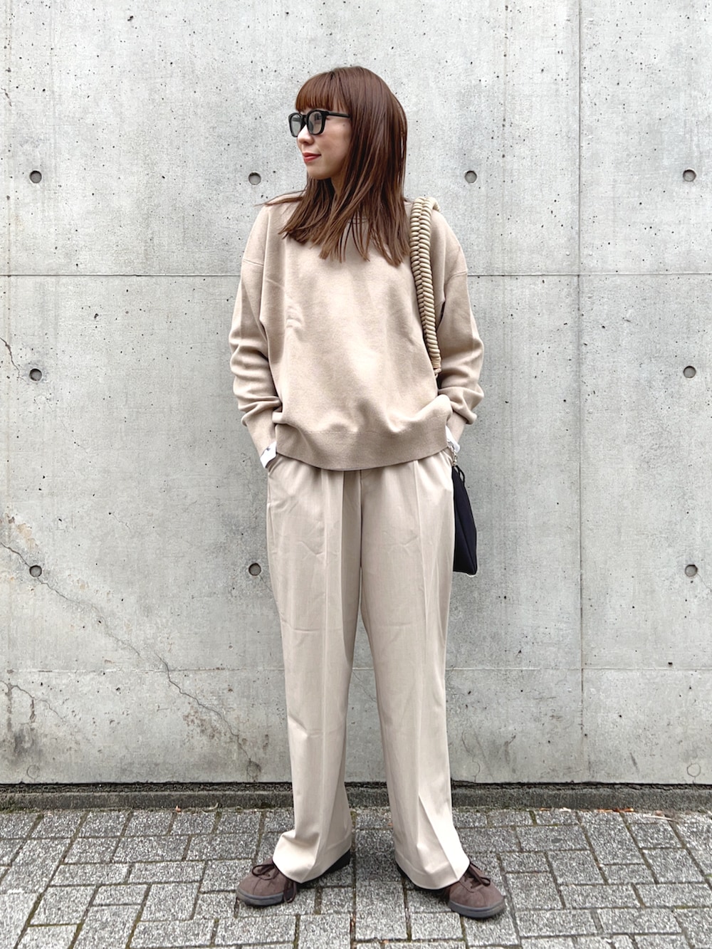 ベージュ系のトップス、ベージュ系のパンツ、ベージュ系のショルダーバッグを着用したレディースの冬コーディネートの2枚目の写真