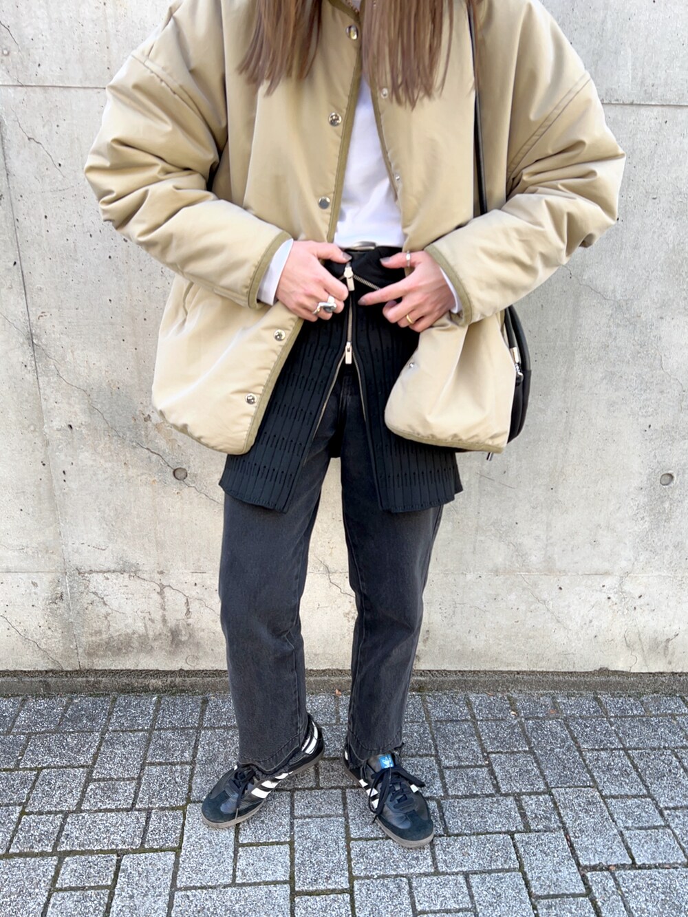 ベージュ系のジャケット/アウター、ホワイト系のTシャツ/カットソー、ブラック系のスラックスを着用したレディースの冬コーディネートの4枚目の写真