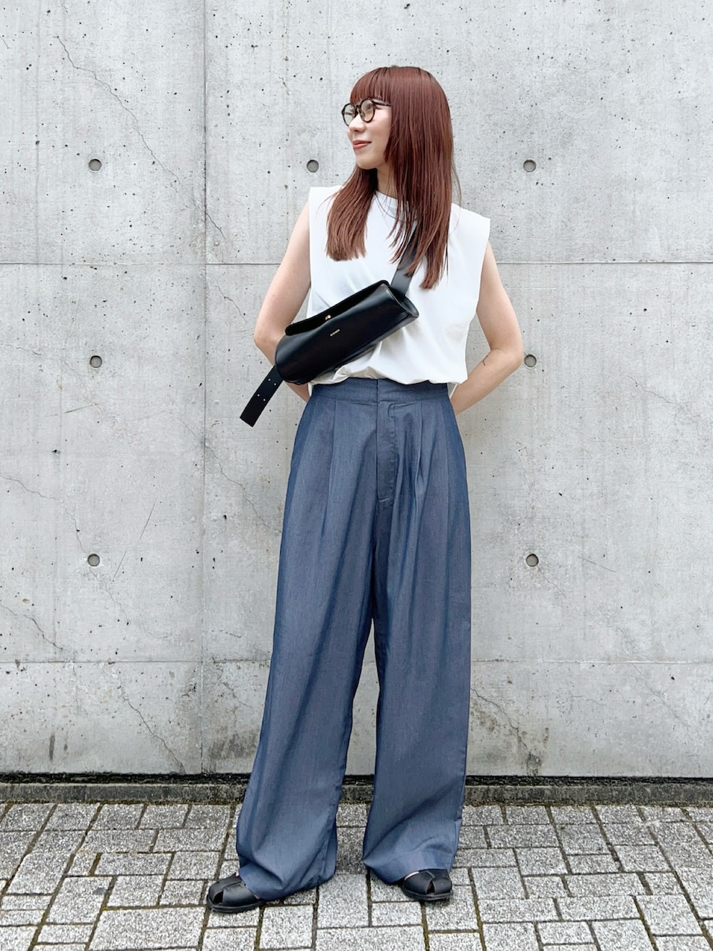 ブルー系のスラックス、ホワイト系のタンクトップ、ブラック系のショルダーバッグを着用したレディースの夏コーディネートの2枚目の写真