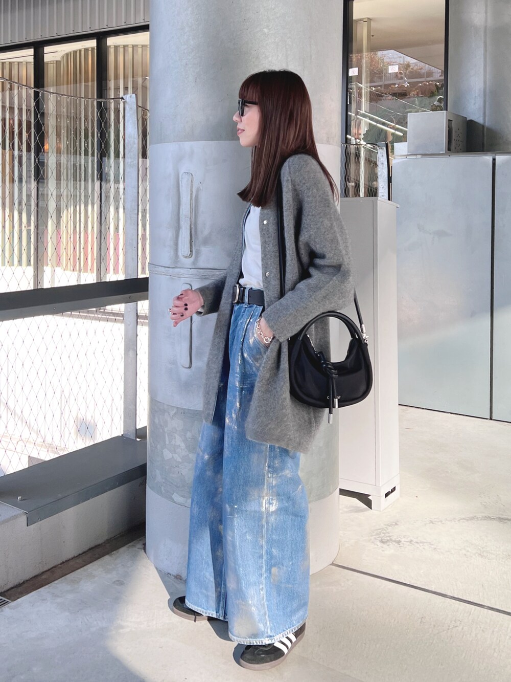 グレー系のその他アウター、ホワイト系のTシャツ/カットソー、ブルー系のデニムパンツを着用したレディースの冬コーディネートの3枚目の写真