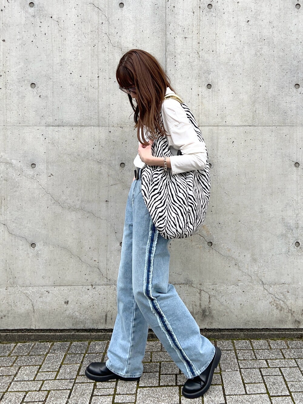 その他のトートバッグ、ホワイト系のTシャツ/カットソー、ブラック系のサンダルを着用したレディースの春コーディネートの2枚目の写真
