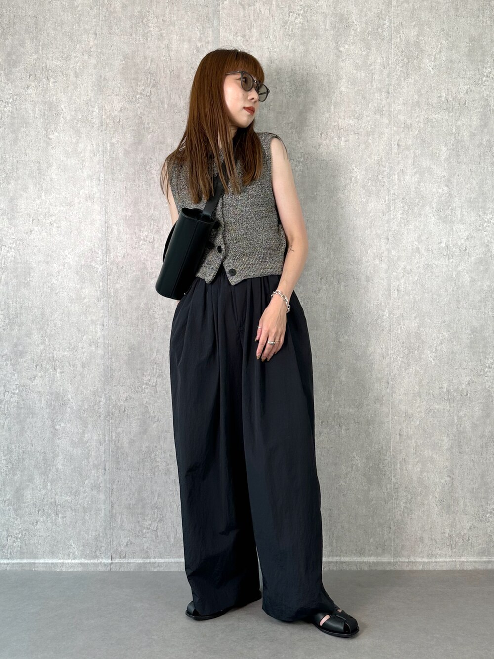 ブラック系のその他パンツ、ブラック系のベスト、ブラック系のショルダーバッグを着用したレディースの夏コーディネートの3枚目の写真