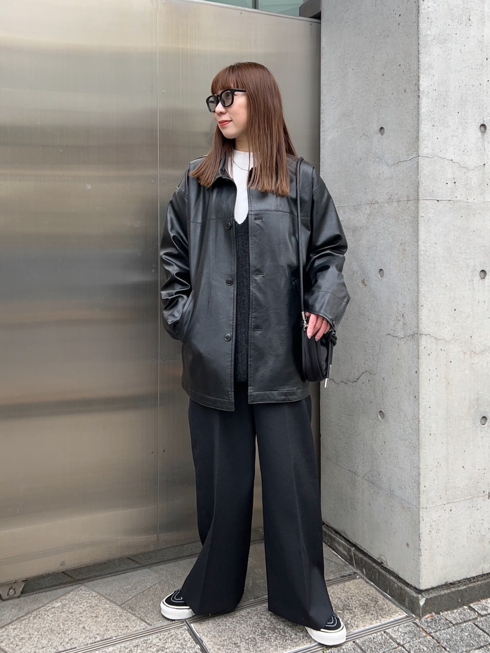 ブラック系のその他アウター、ホワイト系のTシャツ/カットソー、ブラック系のニット/セーターを着用したレディースの冬コーディネートの2枚目の写真