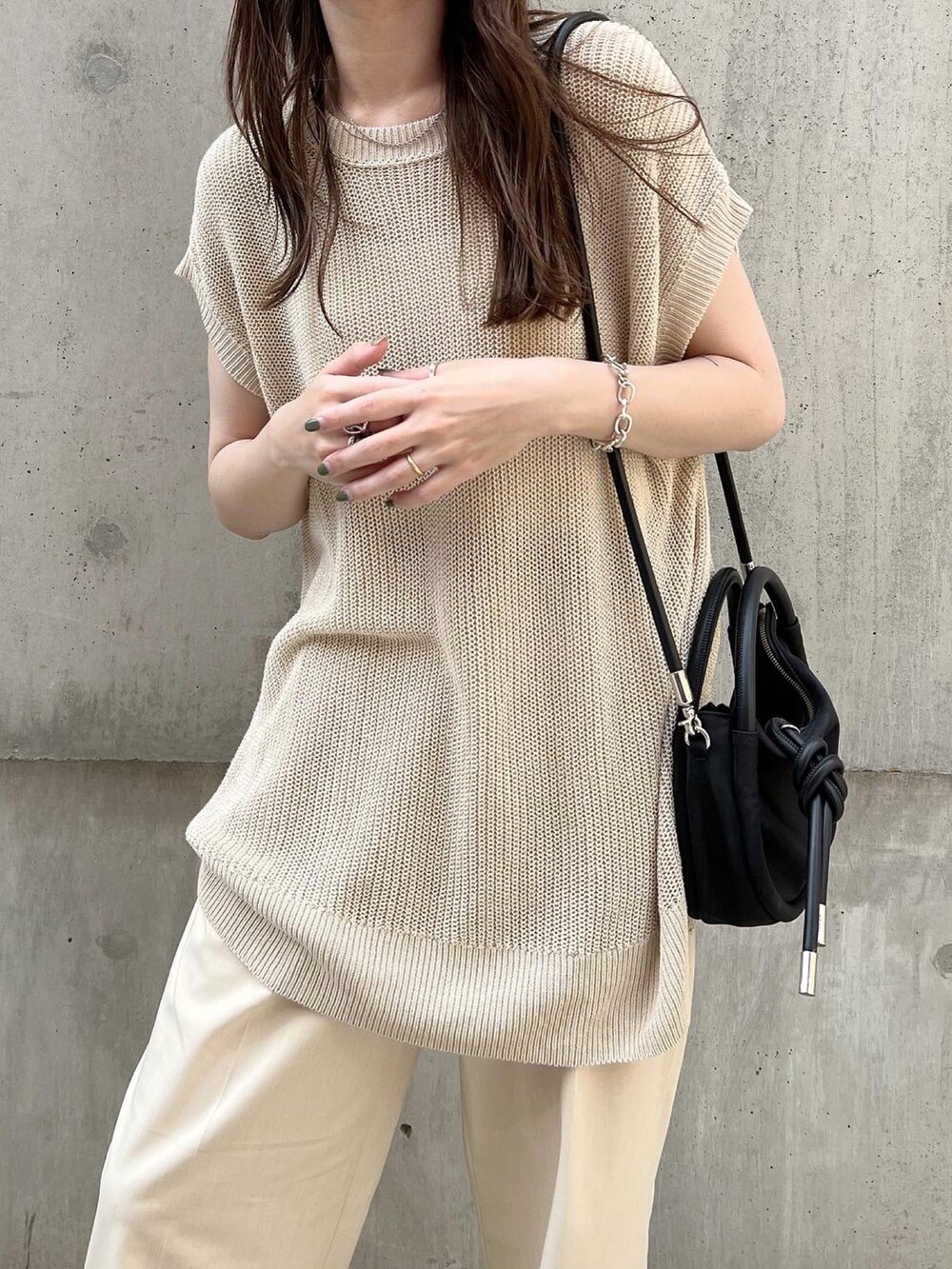 ホワイト系のパンツ、ブラック系のスリッポン、ベージュ系のトップスを着用したレディースの夏コーディネートの4枚目の写真