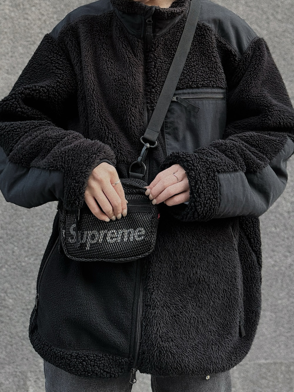 ブラック系のバッグ、ブラック系のブルゾン、ブラック系のデニムパンツを着用したレディースの秋コーディネートの3枚目の写真