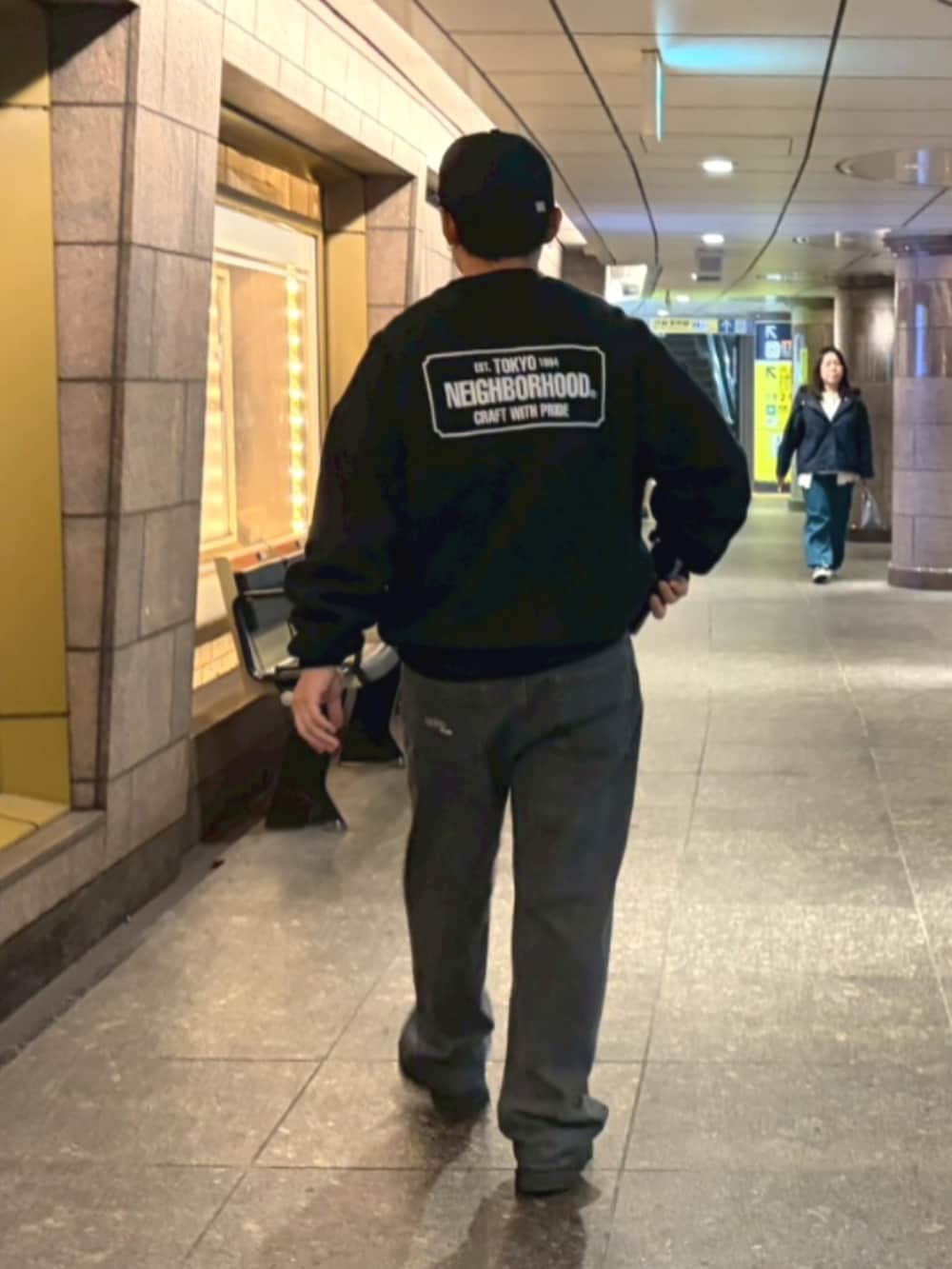 ブラック系のスウェット、ブラック系のデニムパンツ、ブラック系のスニーカーを着用したメンズの春コーディネートの2枚目の写真