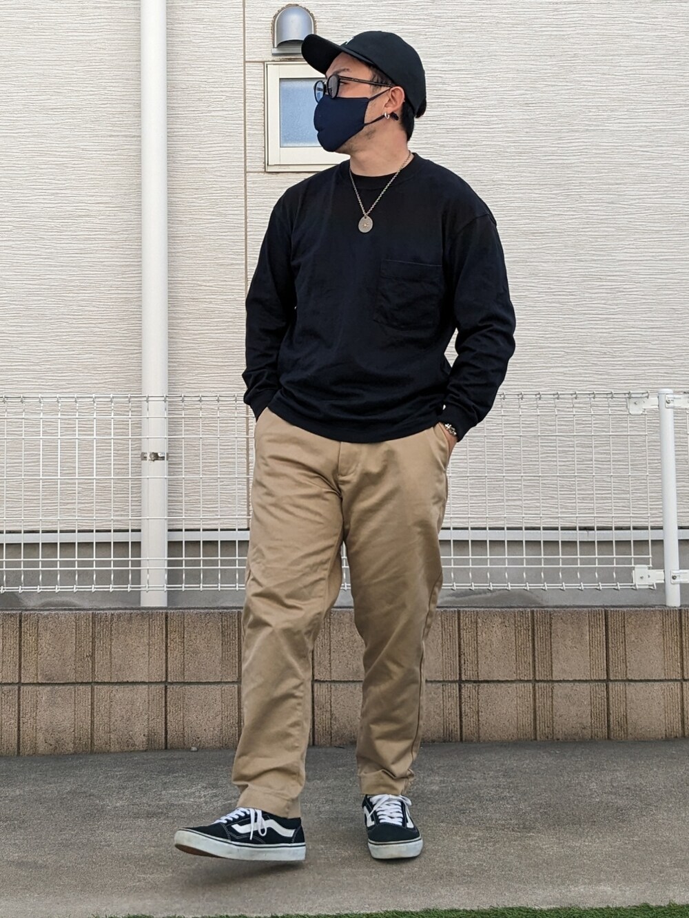 ブラック系のTシャツ/カットソー、ベージュ系のチノパンツ、ブラック系のスニーカーを着用したメンズの春コーディネートの2枚目の写真
