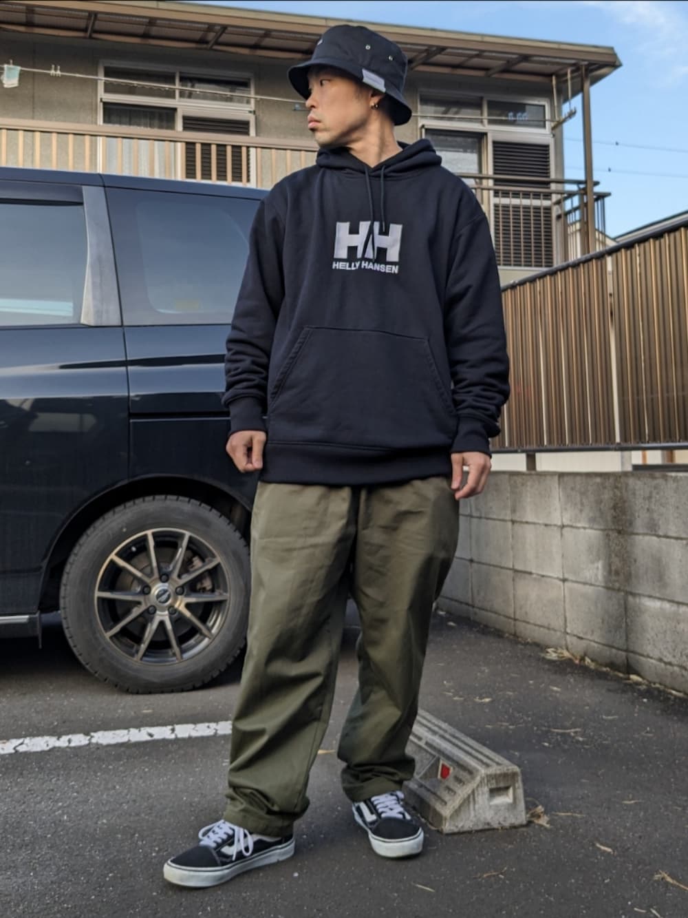 ブラック系のパーカー、グリーン系のその他パンツ、ブラック系のスニーカーを着用したメンズの冬コーディネートの2枚目の写真