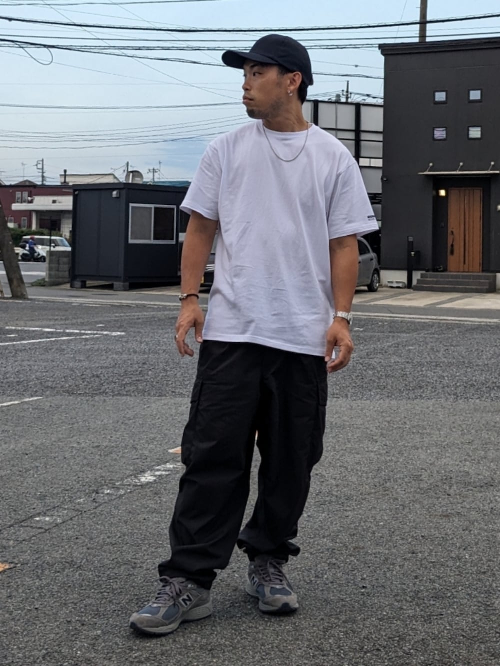 ホワイト系のTシャツ/カットソー、ブラック系のカーゴパンツ、グレー系のスニーカーを着用したメンズの夏コーディネートの2枚目の写真