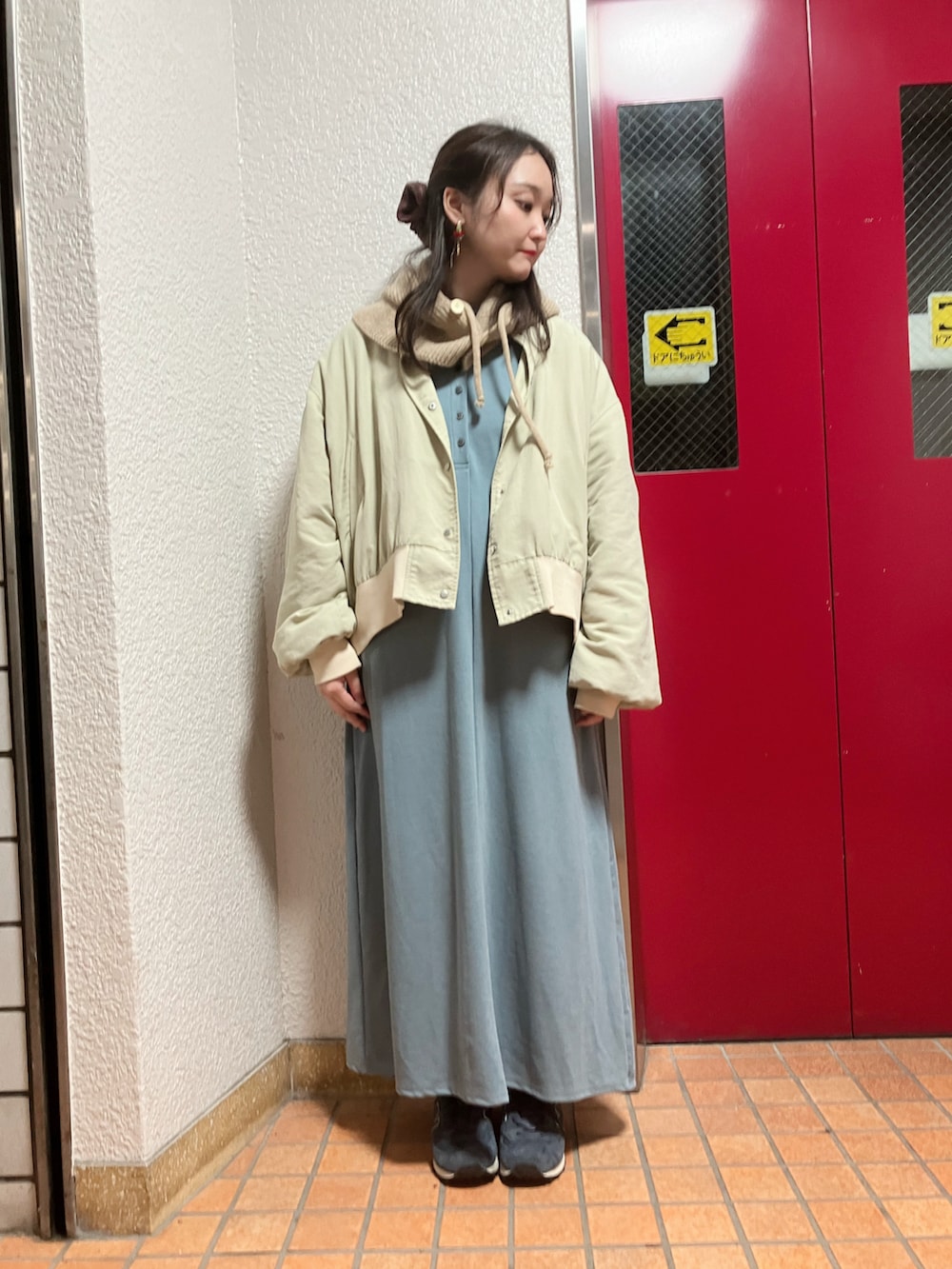 ベージュ系のブルゾン、ブルー系のワンピース、ブルー系のスニーカーを着用したレディースの冬コーディネートの2枚目の写真