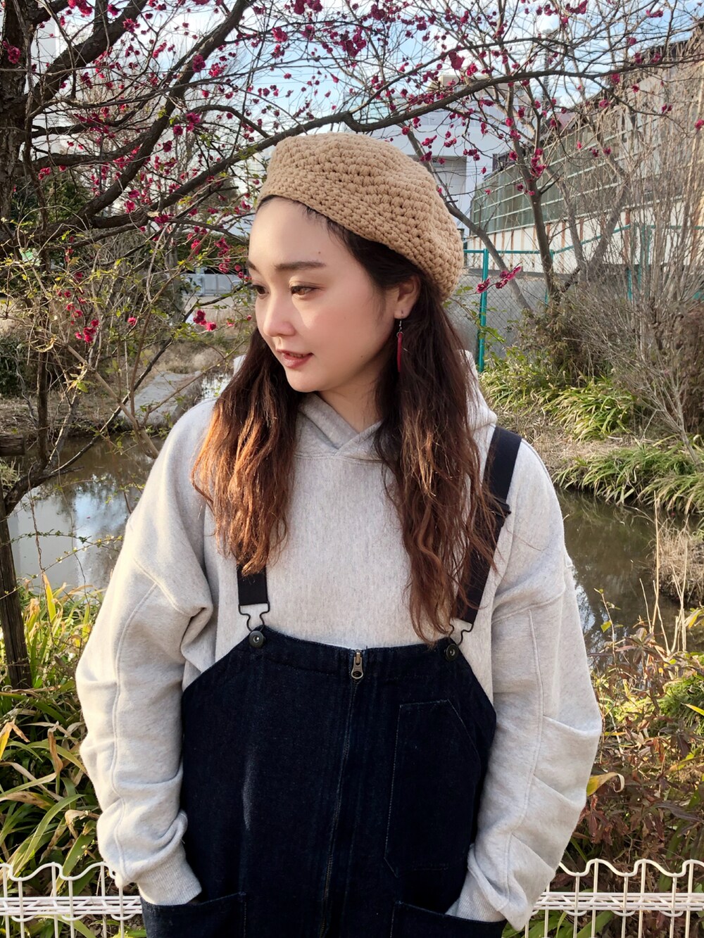 グレー系のパーカー、ブルー系のサロペット/オーバーオール、ホワイト系のミリタリージャケットを着用したレディースの春コーディネートの4枚目の写真