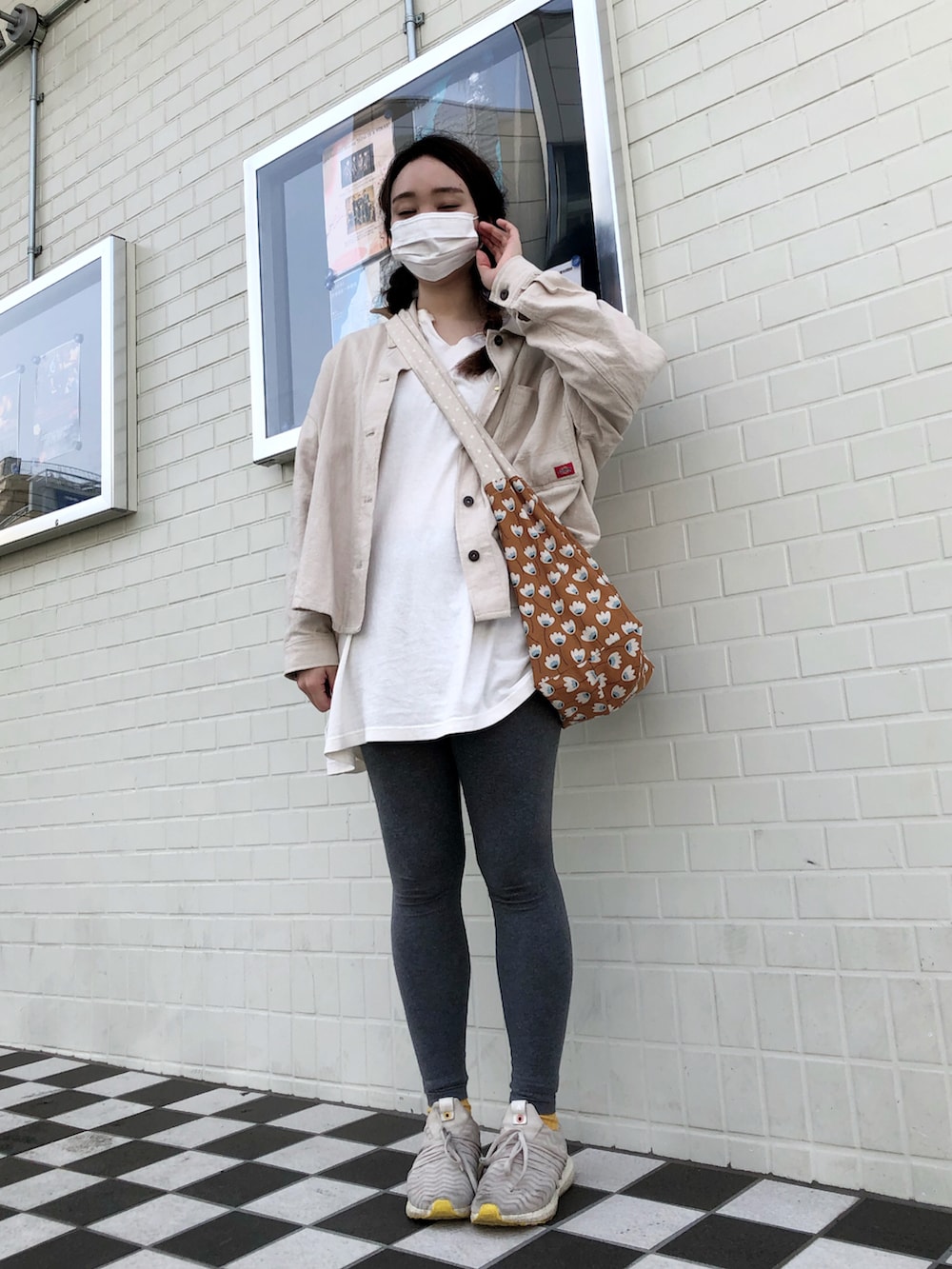 ホワイト系のTシャツ/カットソー、ホワイト系のミリタリージャケット、ブラウン系のショルダーバッグを着用したレディースの春コーディネートの3枚目の写真