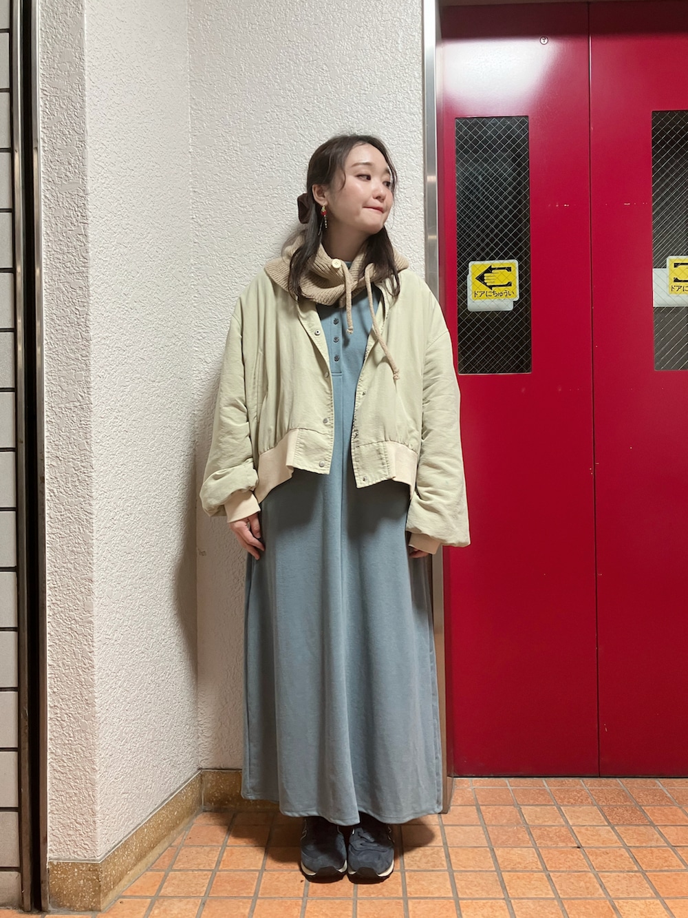 ベージュ系のブルゾン、ブルー系のワンピース、ブルー系のスニーカーを着用したレディースの冬コーディネートの3枚目の写真