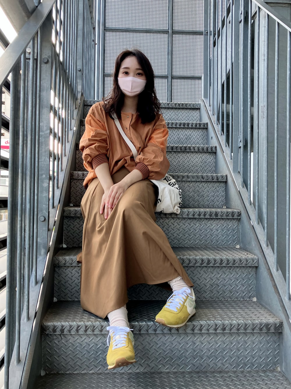 ブラウン系のシャツ/ブラウス、ホワイト系のトートバッグ、ブラウン系のスカートを着用したレディースの秋コーディネートの3枚目の写真