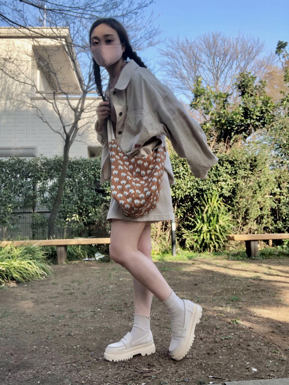 ブラウン系のショルダーバッグ、ホワイト系のミリタリージャケット、ピンク系のTシャツ/カットソーを着用したレディースの春コーディネートの2枚目の写真