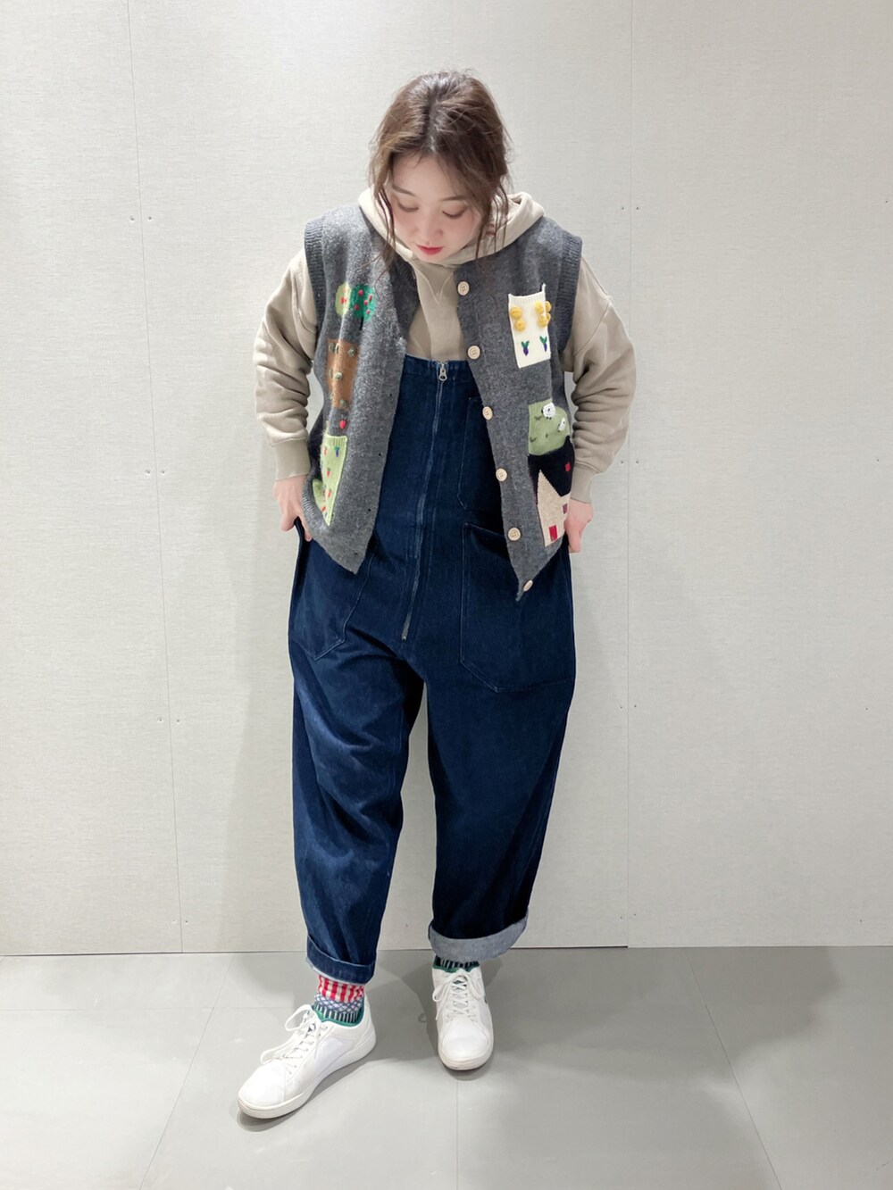 グレー系のベスト、ベージュ系のパーカー、ブルー系のサロペット/オーバーオールを着用したレディースの秋コーディネートの4枚目の写真