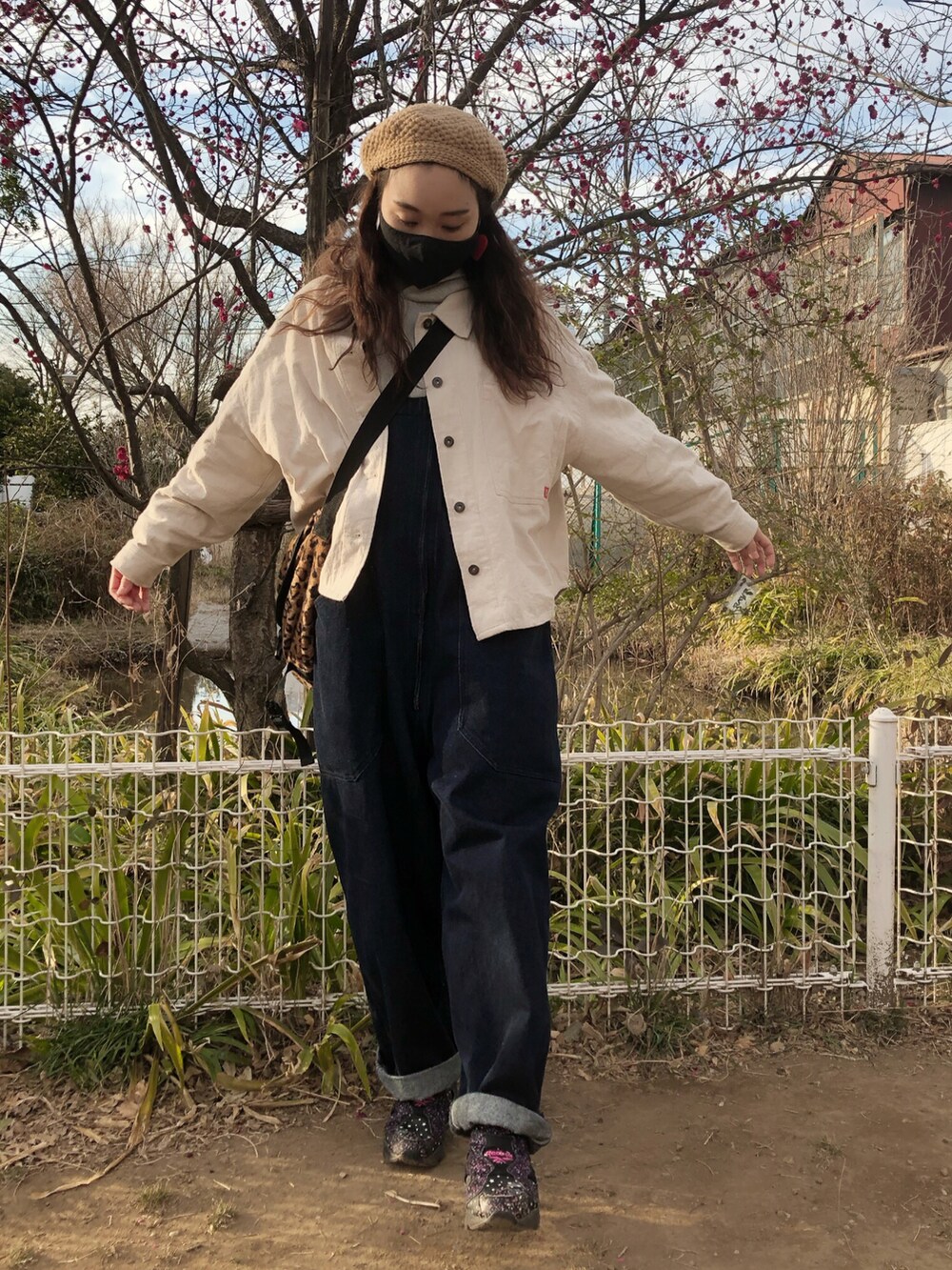 グレー系のパーカー、ブルー系のサロペット/オーバーオール、ホワイト系のミリタリージャケットを着用したレディースの春コーディネートの2枚目の写真