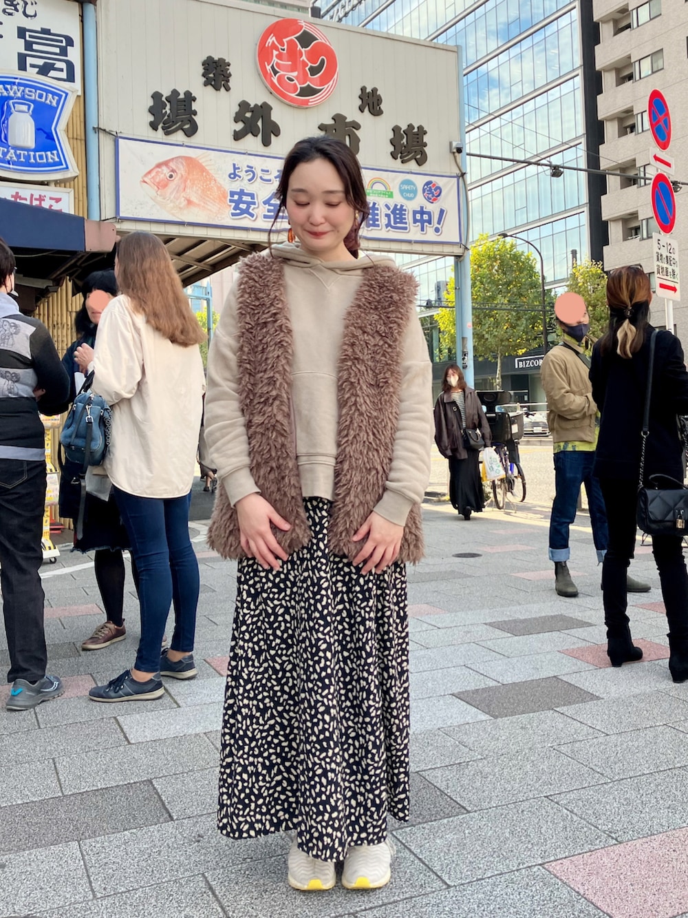 ベージュ系のパーカー、ブラウン系のベスト、ブラック系のスカートを着用したレディースの秋コーディネートの3枚目の写真