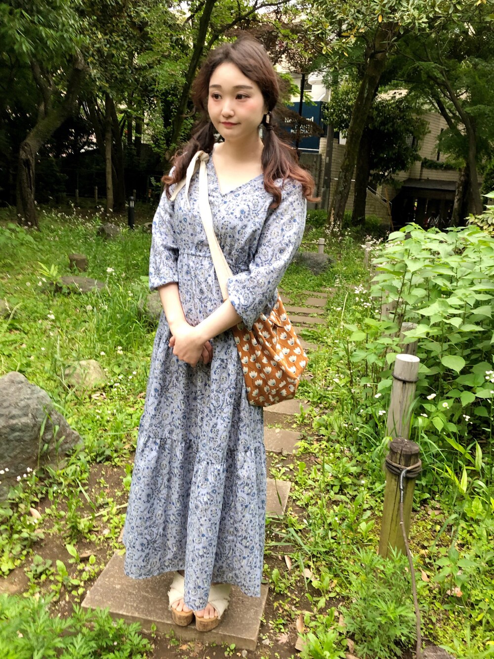 ブルー系のワンピース、ブラウン系のショルダーバッグ、ホワイト系のサンダルを着用したレディースの春コーディネートの2枚目の写真