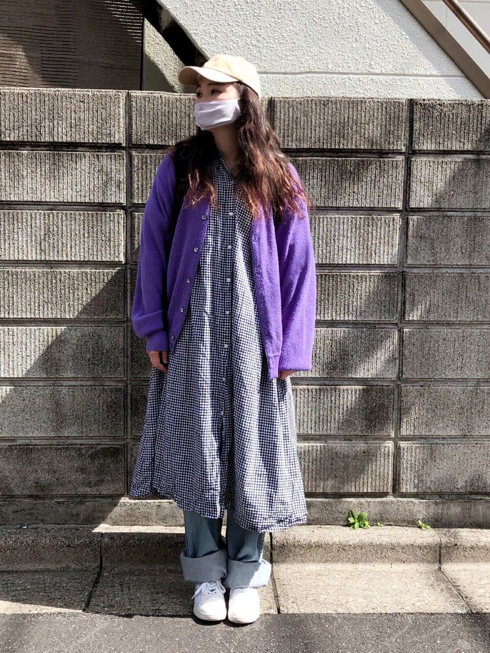 パープル系のカーディガン/ボレロ、ブラック系のワンピース/ドレス、ブルー系のデニムパンツを着用したレディースの春コーディネートの2枚目の写真