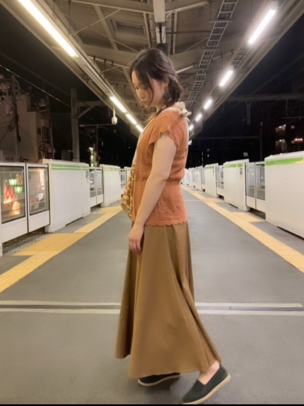 ベージュ系のタンクトップ、ブラウン系のショルダーバッグ、ブラウン系のベストを着用したレディースの秋コーディネートの2枚目の写真