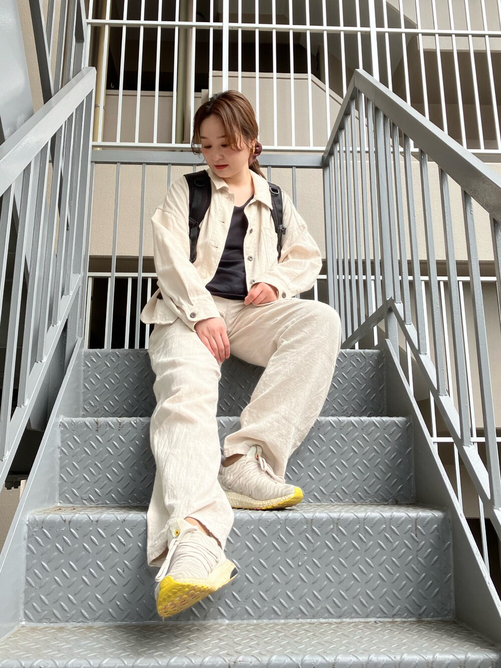 ホワイト系のミリタリージャケット、ホワイト系のその他パンツ、グレー系のスニーカーを着用したレディースの春コーディネートの2枚目の写真